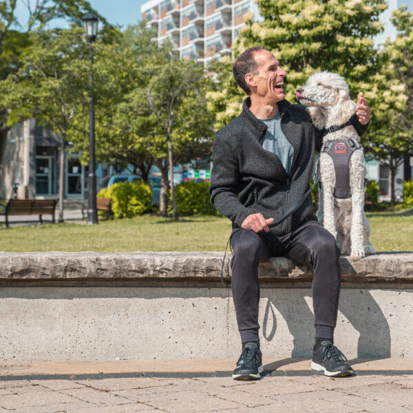 A man who is blind laughs as his Guide Dog kisses him