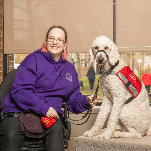 woman in wheelchair sits next to Service Dog